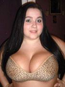 Seductive busty brunette toys mouth with a big dildo