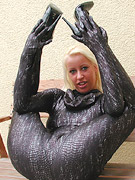 Two rubber dominas whipping bondaged latex slave girl in the dungeon