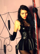 Hot brunette nymph in fishnet stocking and latex undies stripteasing by the wall.